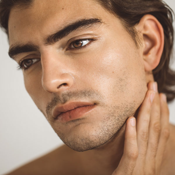 closeup of man with strong jaw line touching the side of his face