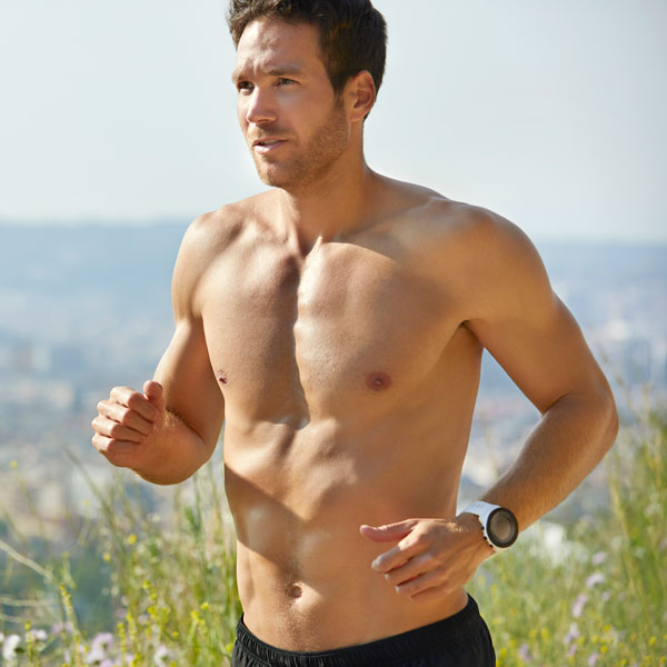 shirtless man jogging on a sunny day