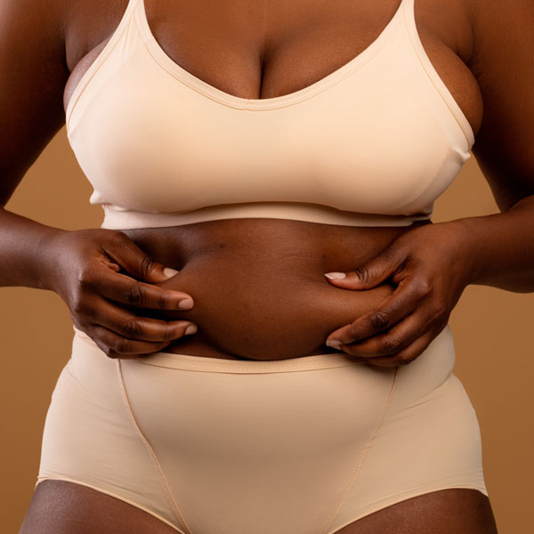 closeup of woman grabbing her stomach fat