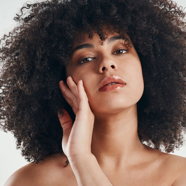 closeup of woman with large afro and her hand touching the side of her face