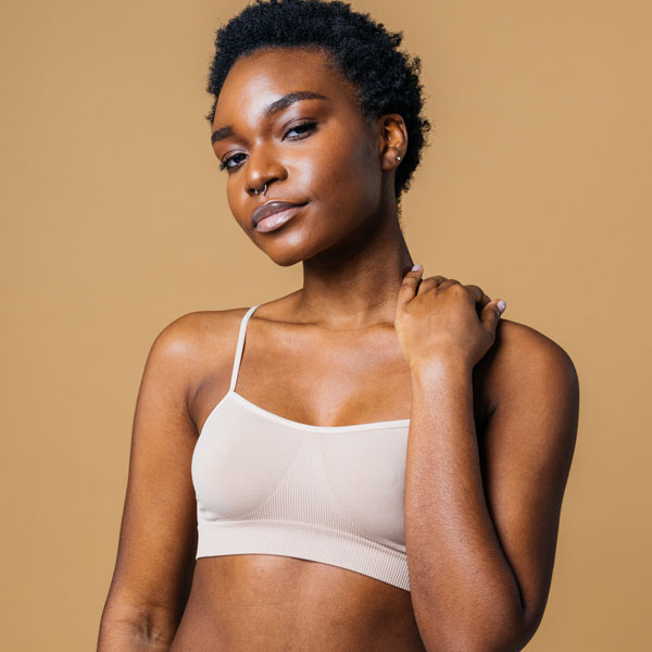 woman in sports bra with her arm bent up and hand resting on shoulder