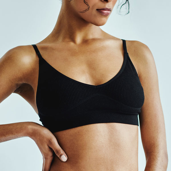 closeup of woman in black bra with hand on side