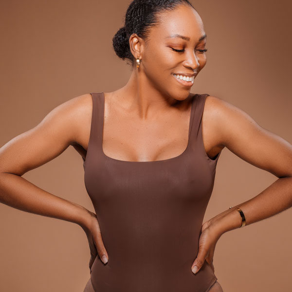 woman looking to the side with both hands on her hips