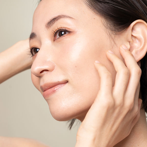 closeup of woman with fingers touching the side of her face